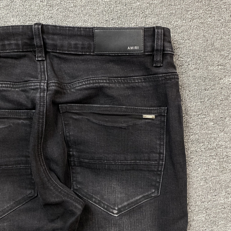 Calça Amiri Skinny Jeans Staggered Logo Black zoom frente em fundo real