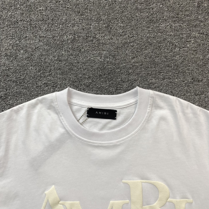 Camiseta Amiri Staggered Logo White zoom frente em fundo real