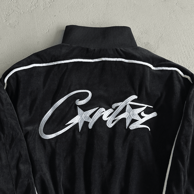 Conjunto Corteiz Velvet Trackset Black  casaco tras zoom em fundo real